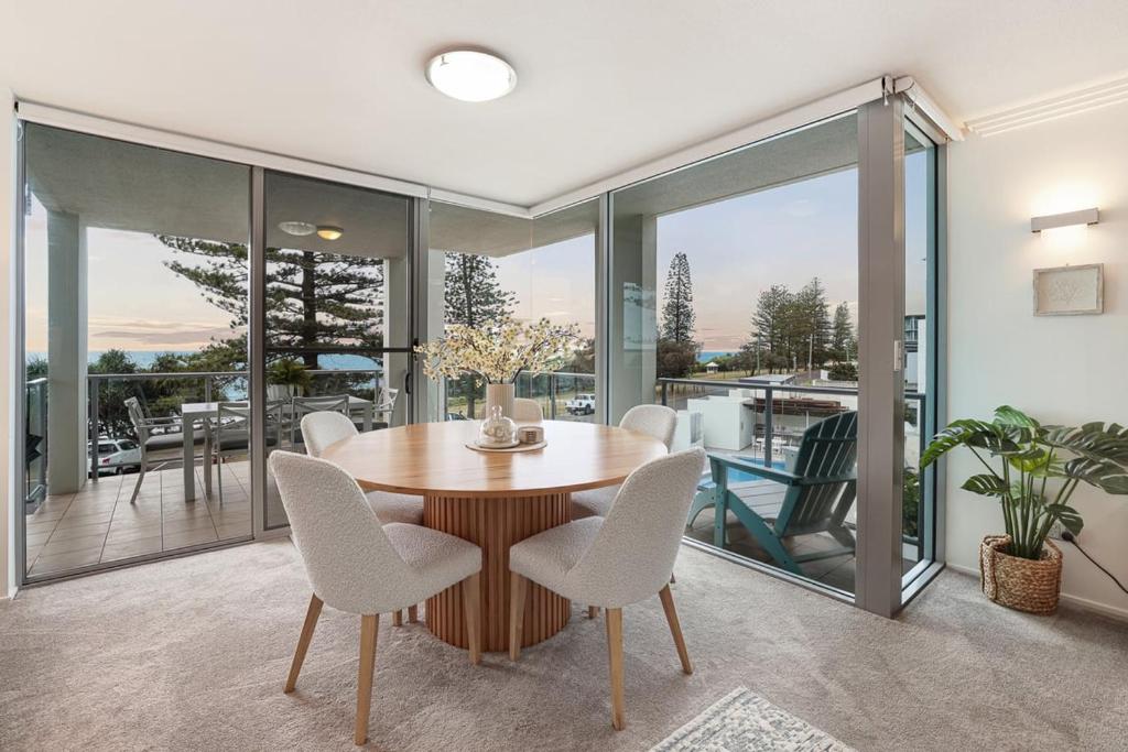 een eetkamer met een tafel en stoelen bij Dwell at 38, Oceanfront Apartment in Bargara