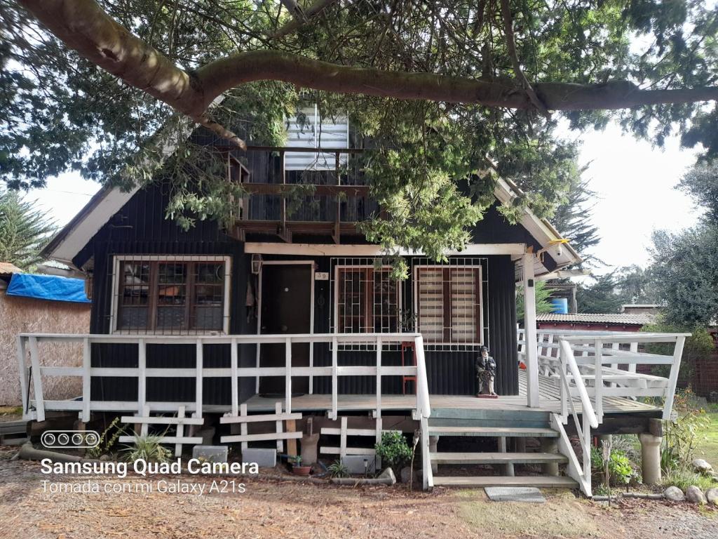 a house with a porch and a dog standing in front of it at Casa completa en Horcón para 8 personas in Puchuncaví