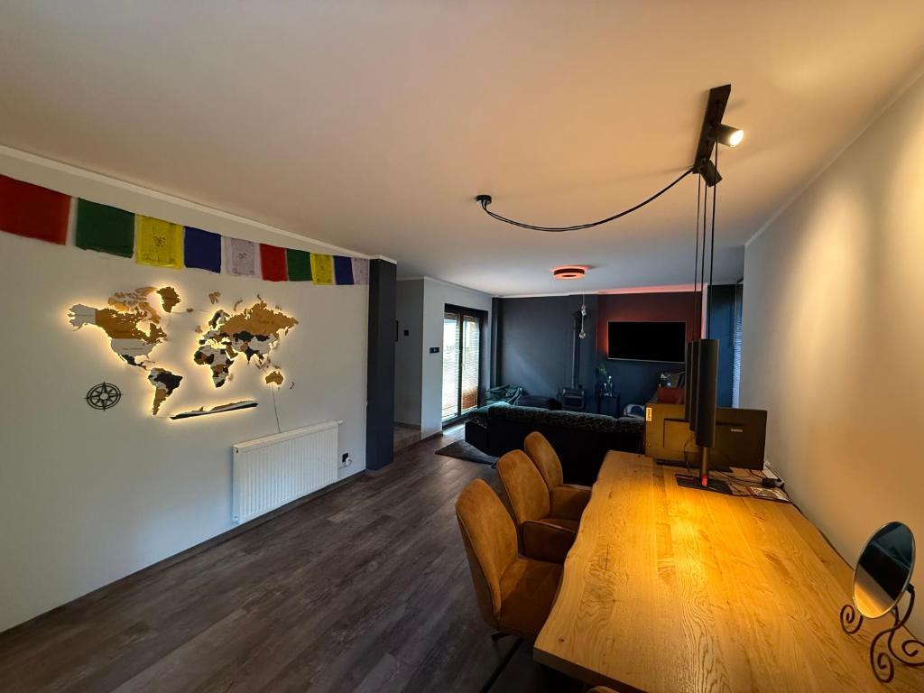 una sala de estar con una mesa y un mapa mundial en la pared en Dom pod lasem, en Bielsko-Biala