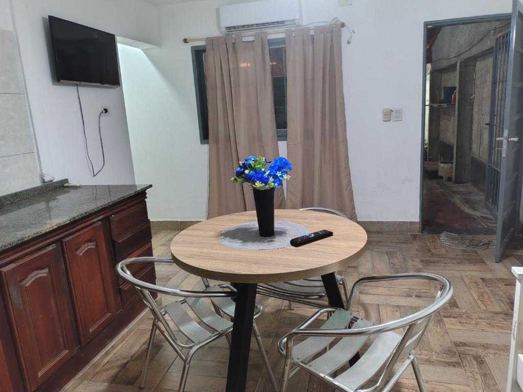 une petite table avec un vase contenant des fleurs bleues dans l'établissement Casa en alquiler por día en La Rioja, à La Rioja