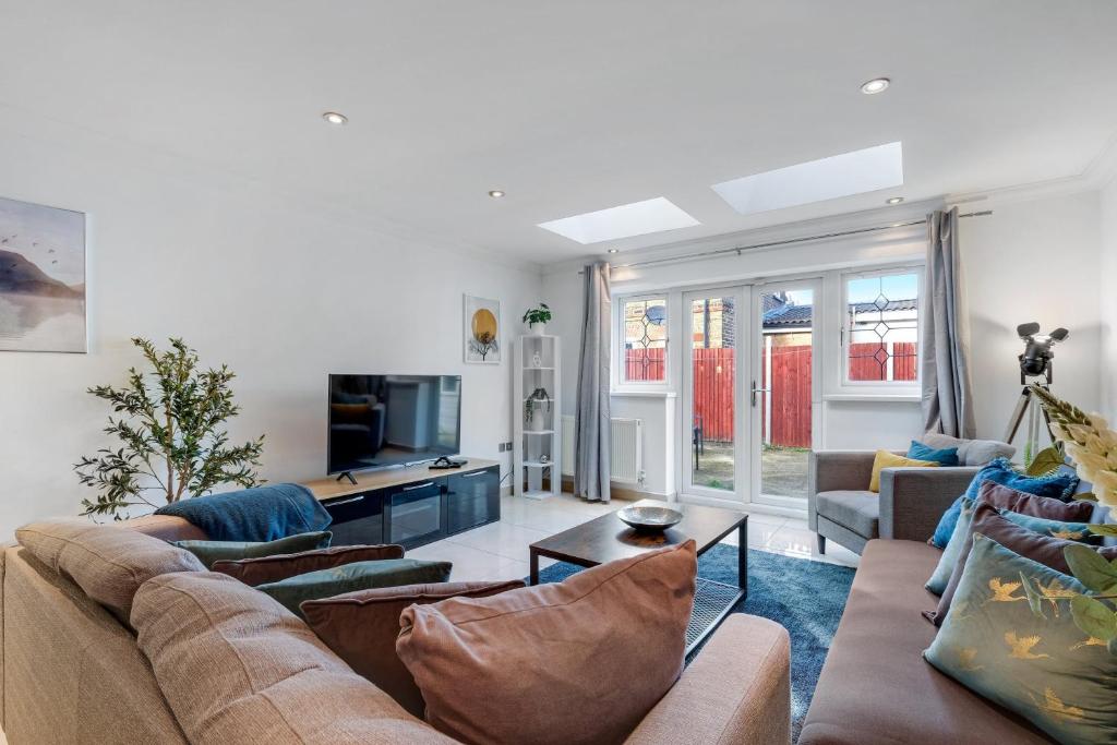 a living room with a couch and a tv at Isher 3 Bedroom, 2-Bathroom House with Parking in Uxbridge