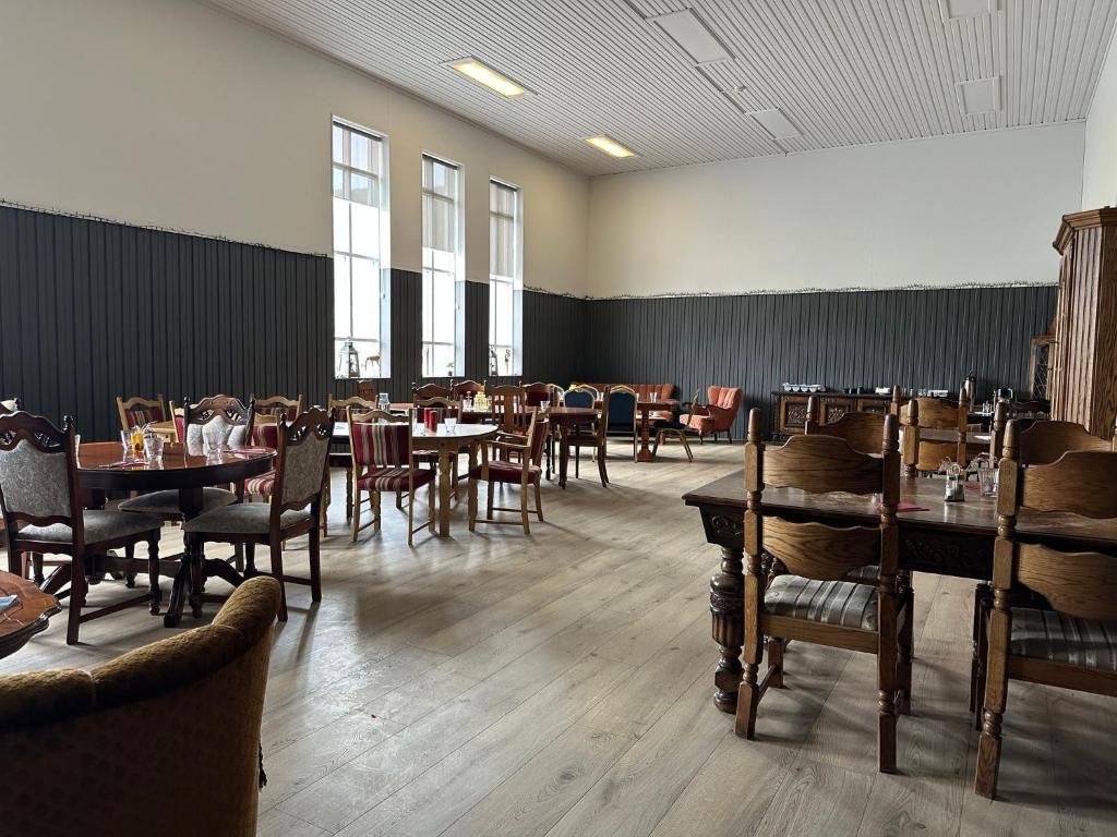 ein Restaurant mit Tischen und Stühlen in einem Raum in der Unterkunft Studlagil INN Hostel in Skjöldólfsstaðir