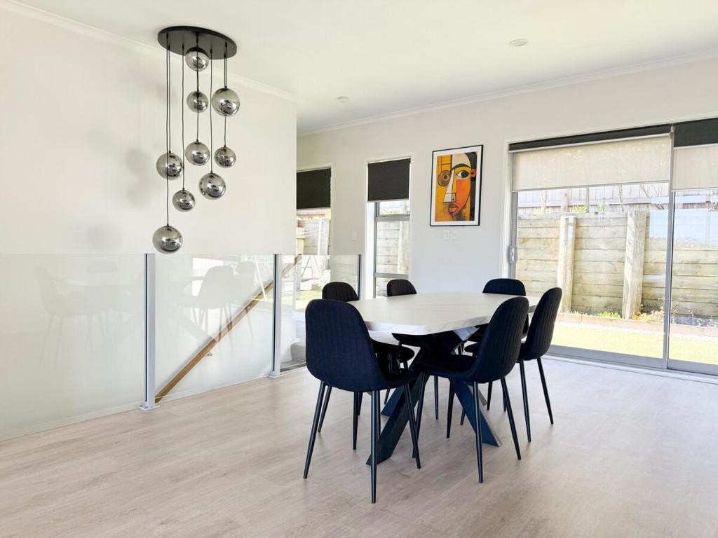 una sala da pranzo con tavolo e sedie di Cosy Luxe --Modern 3 bedroom home in Johnsonville a Wellington