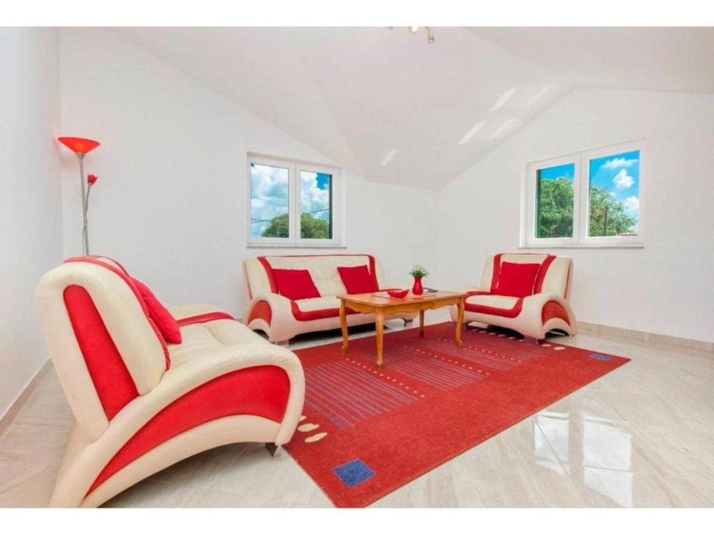 - un salon avec des chaises rouges et blanches et une table dans l'établissement Four Bedroom Villa with the pool, à Brištane