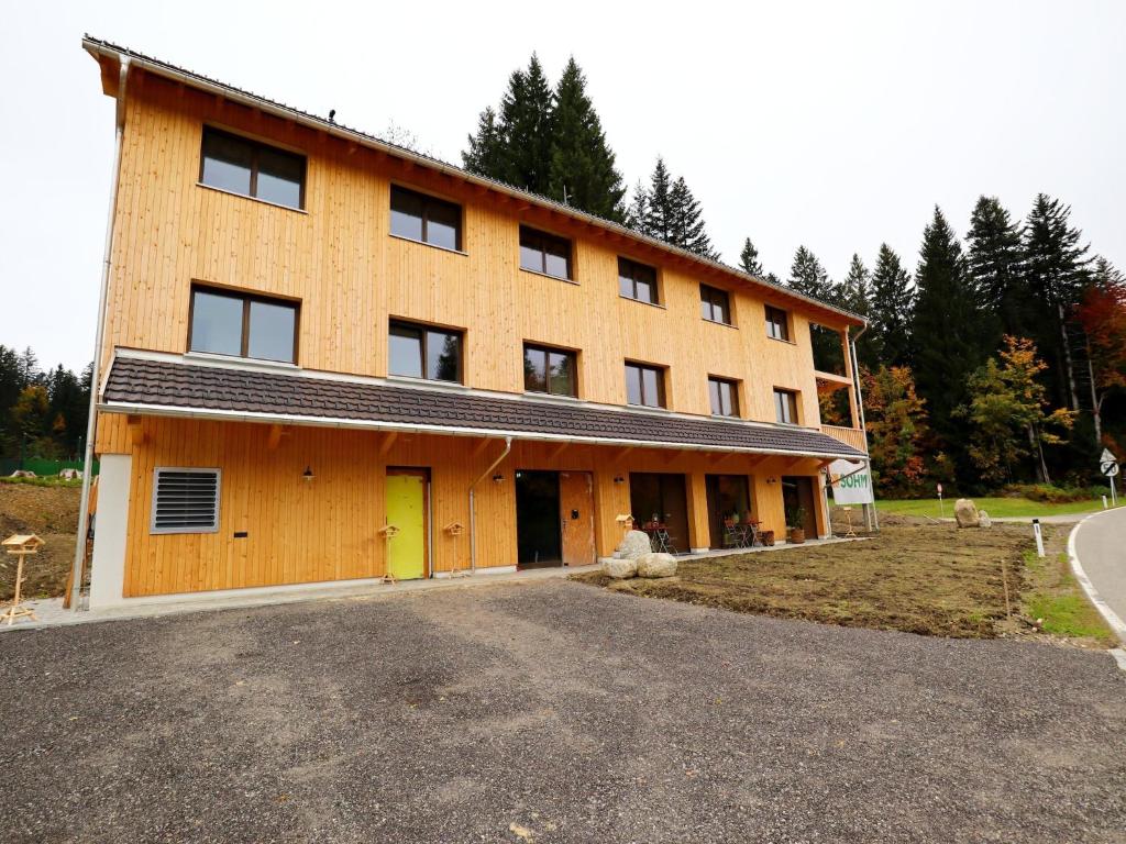 a large wooden building with a yellow door at Dog-friendly holiday apartment in Bregenzerwald in Sibratsgfäll