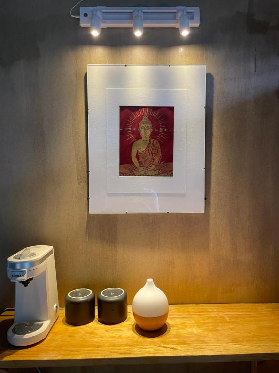 a table with a coffee maker and a picture on a wall at EB5 Escape Tzununa, Lake Atitlan Room #1 - two minute walk to the Lake in Santa Cruz La Laguna