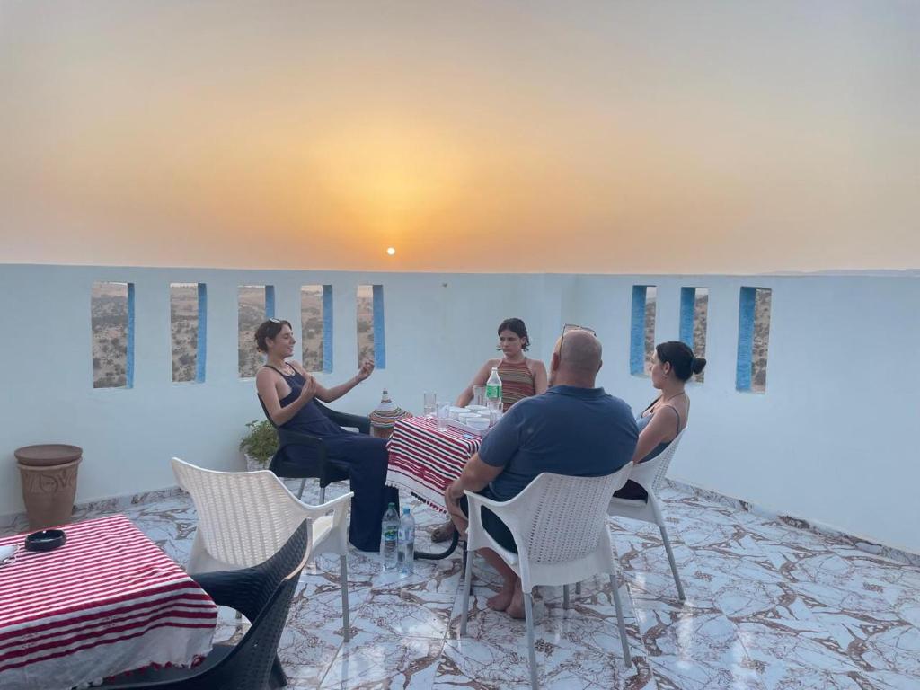 a group of people sitting around a table in a room at Azour House in Taghazout