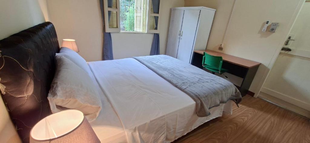 a bedroom with a large white bed in a room at Casa Lara - Carmelitas Asunción in Asuncion
