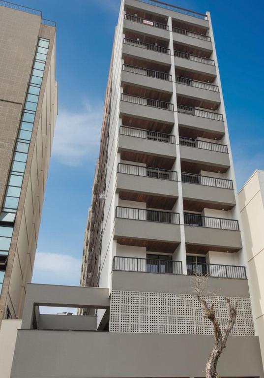 an apartment building with a tree in front of it at Studio Moderno com automação e vista incrível in Juiz de Fora