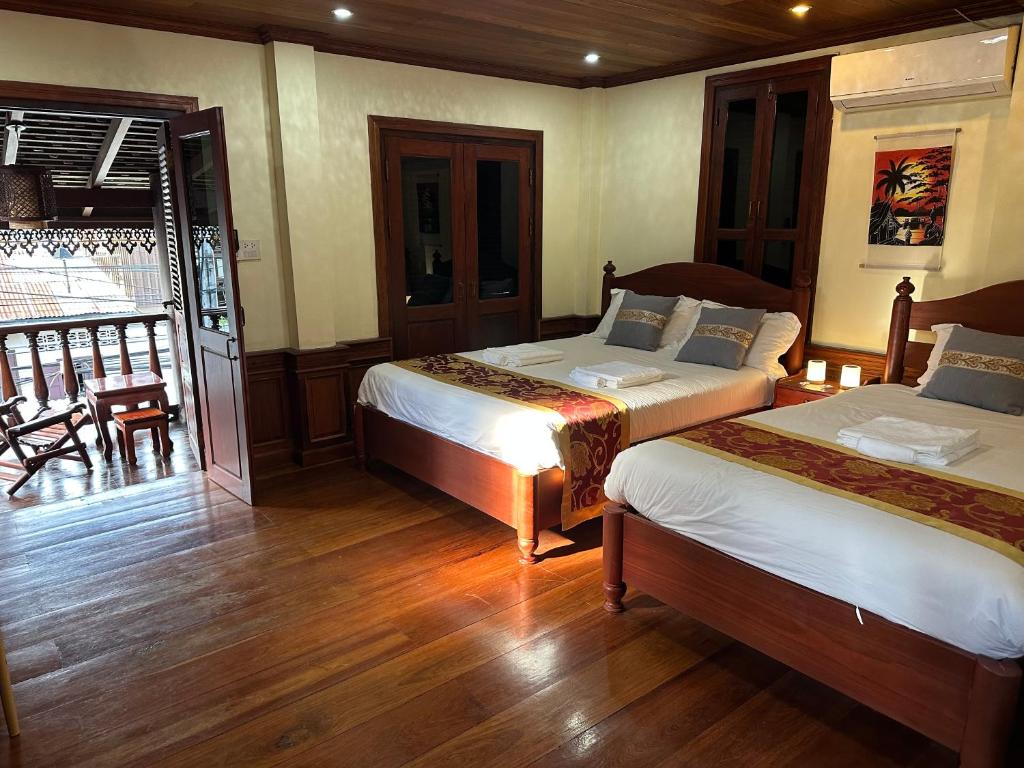 琅勃拉邦RainForest Guest Lodge的有两张床和一个阳台的酒店房间