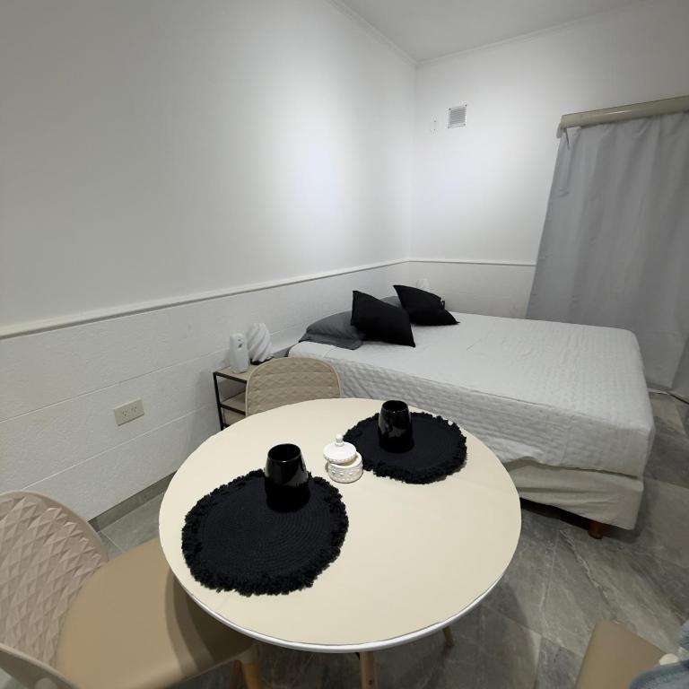 a room with a bed and a white table with hats on it at Espacio Uno B in Belén de Escobar