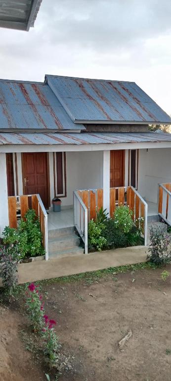 a house with a rusted roof on the porch at Pin senaru accomodation in Senaru
