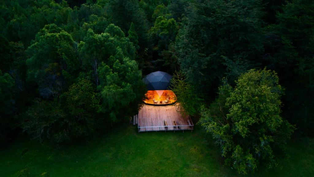een bovenaanzicht van een vuurplaats met een parasol bij Alma Andina in Puelo
