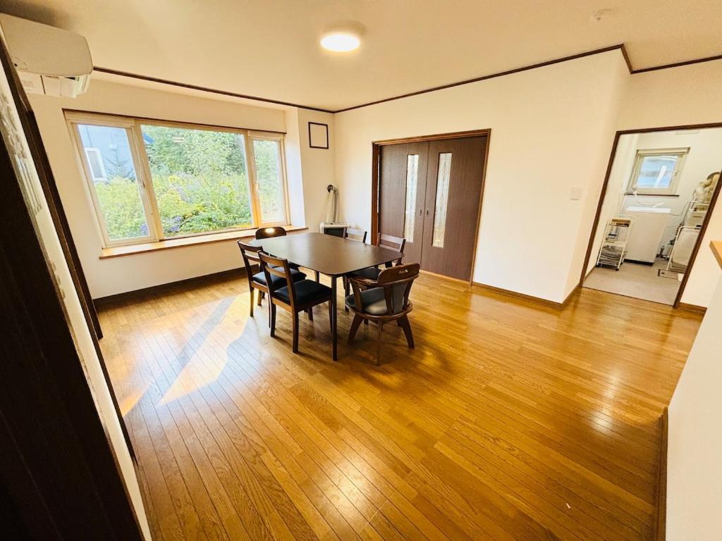 een eetkamer met een tafel en stoelen bij Kamui Adventure House in Asahikawa