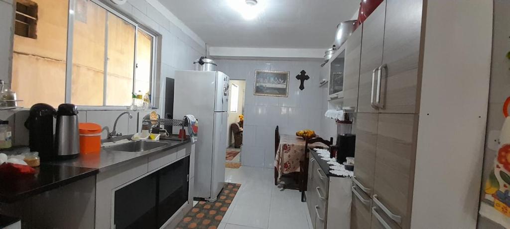 een keuken met een spoelbak en een koelkast bij Casa compartilhada para Natal Luz e FIG in Garanhuns
