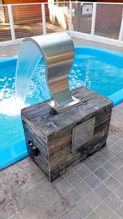 a water fountain in front of a swimming pool at Cabañas flotter in Villa Ventana