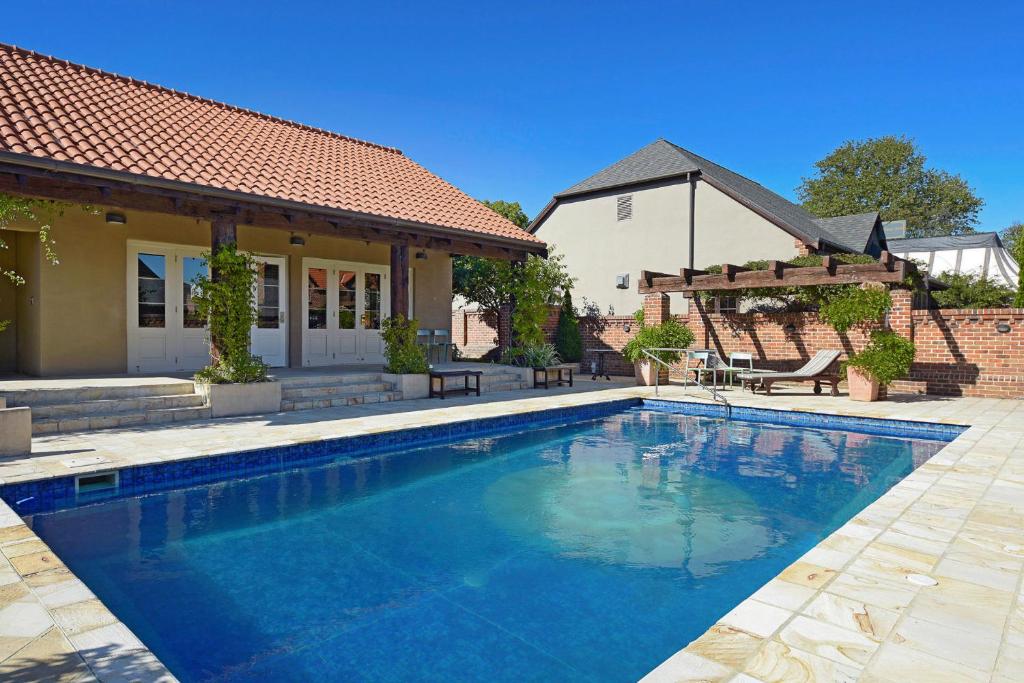 a swimming pool in front of a house at Monaco Shores Apartment in Nelson
