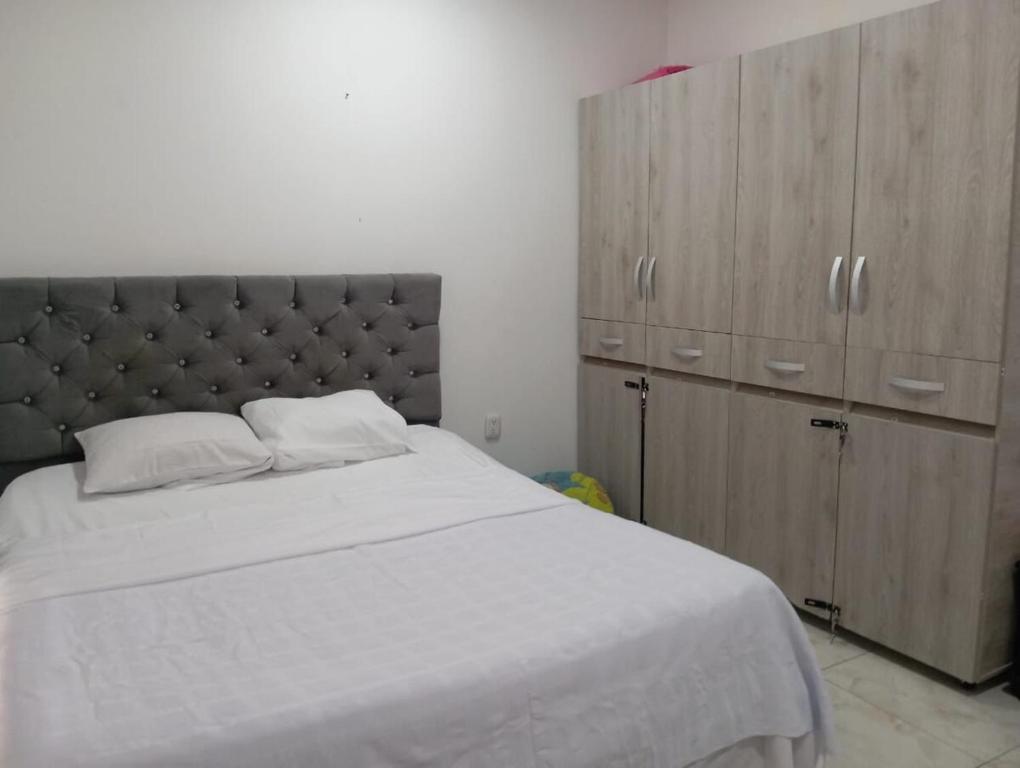 a bedroom with a large bed and wooden cabinets at Casa vacacional El Oasis in Villavicencio