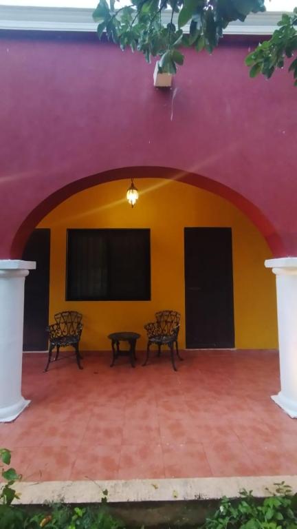 two benches sitting in front of a wall at Casa Mango in Mérida