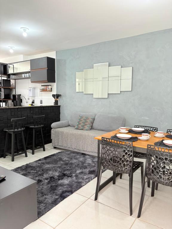 ein Wohnzimmer mit einer Couch und einem Tisch mit Stühlen in der Unterkunft Apê moderno perto do shopping - WI-FI rápido e garagem in Caruaru