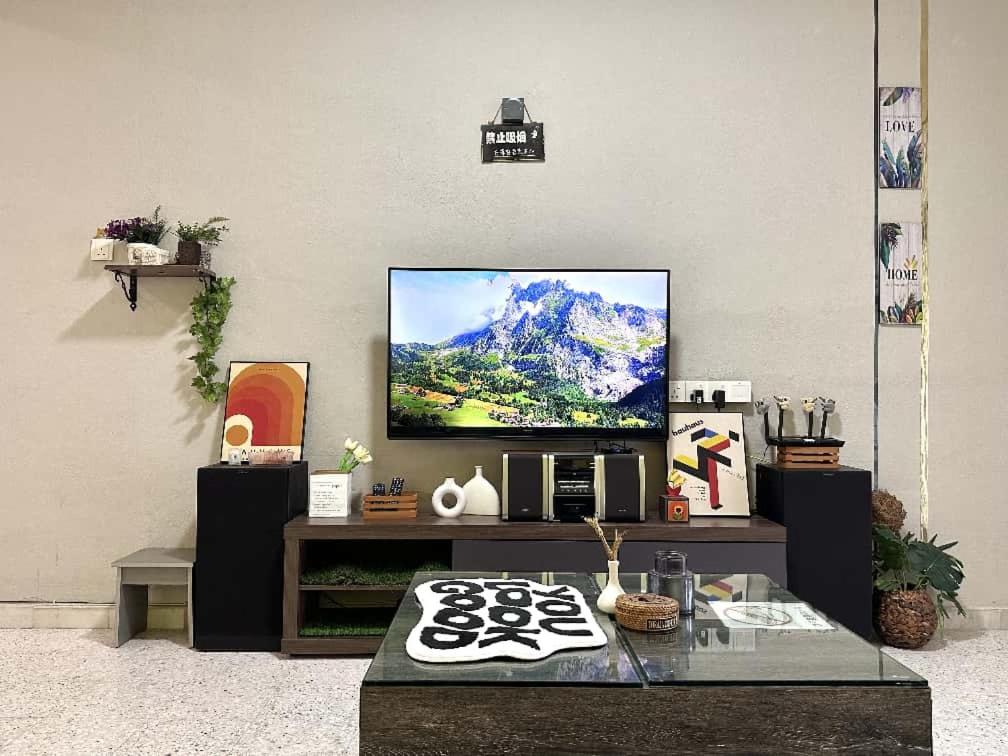 ein Wohnzimmer mit einem Flachbildfernseher an der Wand in der Unterkunft Modern Cozy Sweet House 4 ROOM 10pax@ALMA BM in Bukit Mertajam