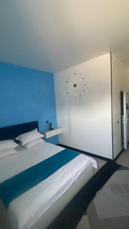 ein Schlafzimmer mit einem großen Bett mit einer blauen Wand in der Unterkunft Madani in Arys