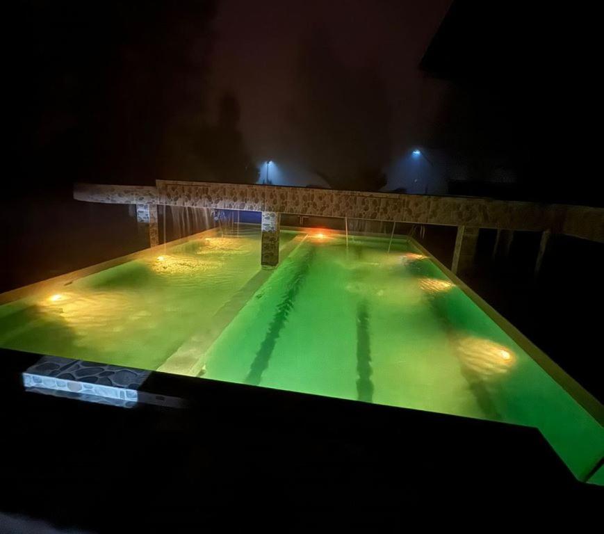 een zwembad 's nachts met groene verlichting bij Departamento Campestre in Ibarra