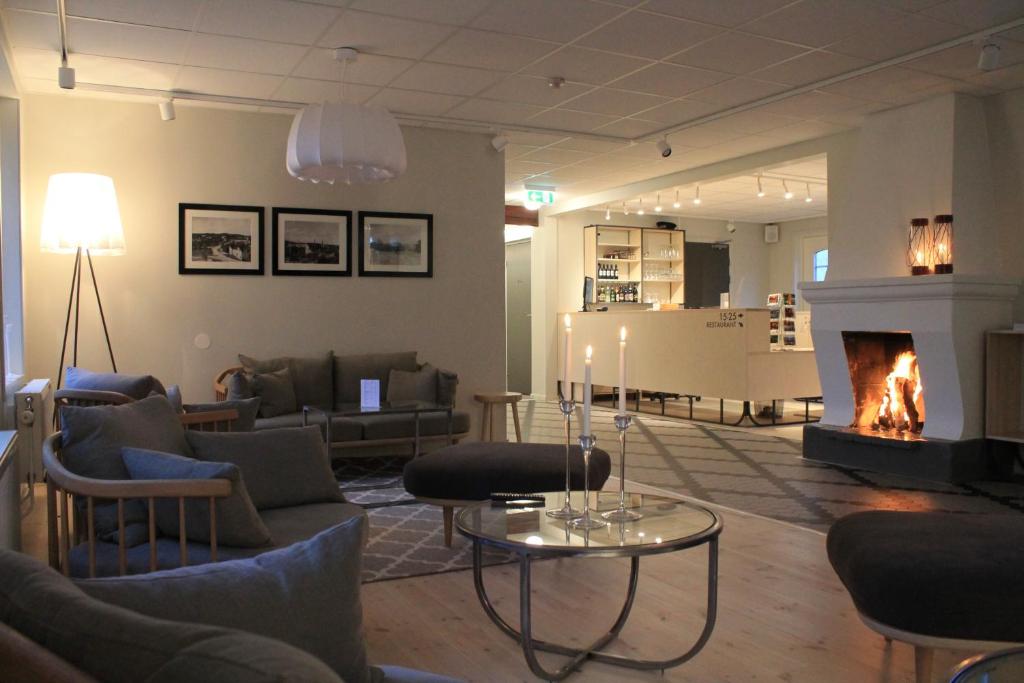 sala de estar con chimenea y sofás en Hotel Akerlund, en Jokkmokk