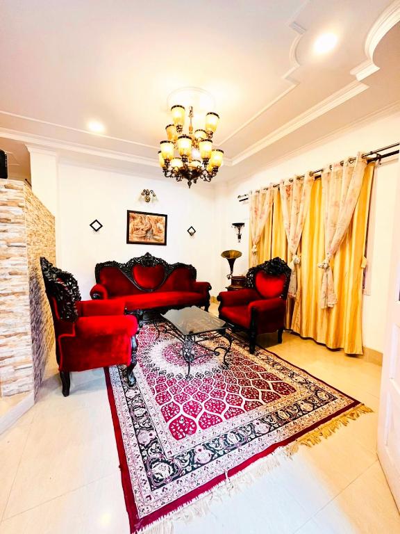una sala de estar con sofás rojos y una alfombra en The Divine Abode Homestay, en Guwahati