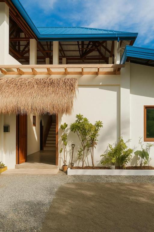 a house with a thatched roof and a staircase at TangboSurfHouse in Alegria