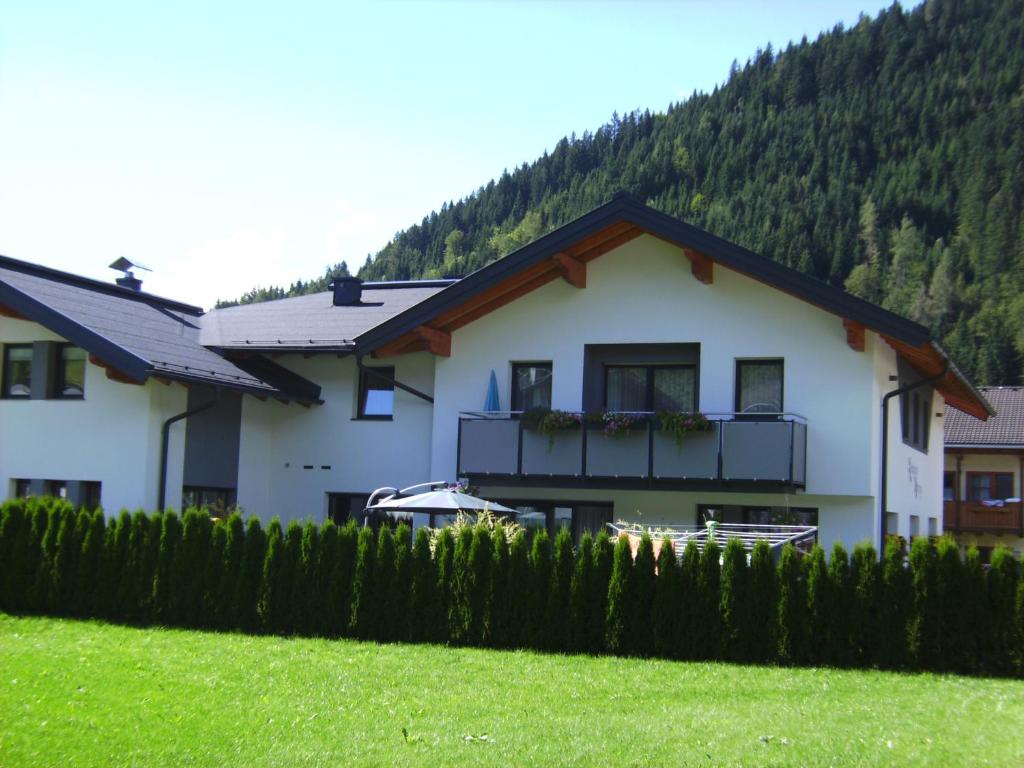 a white house with a balcony and a yard at Landhaus Marina in Werfenweng