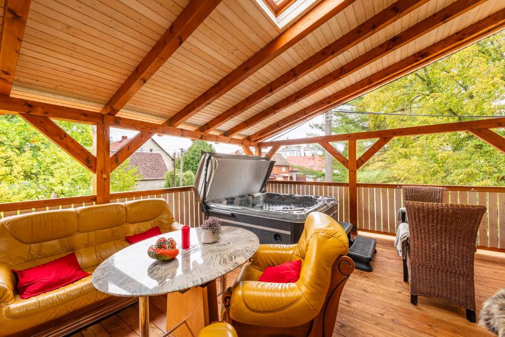 a screened in porch with a table and chairs and a grill at Elements Apartments & Renata in Božičany