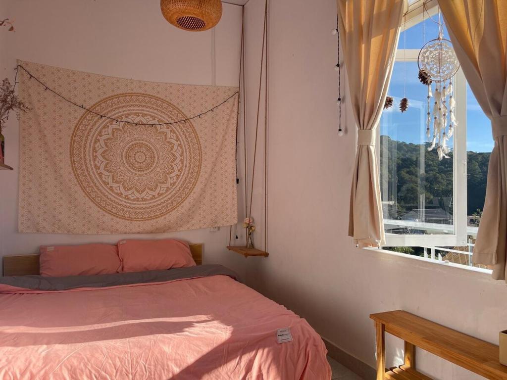 a bedroom with a bed and a window at Roxie home view thung lũng,săn mây, gần trung tâm in Xuan An