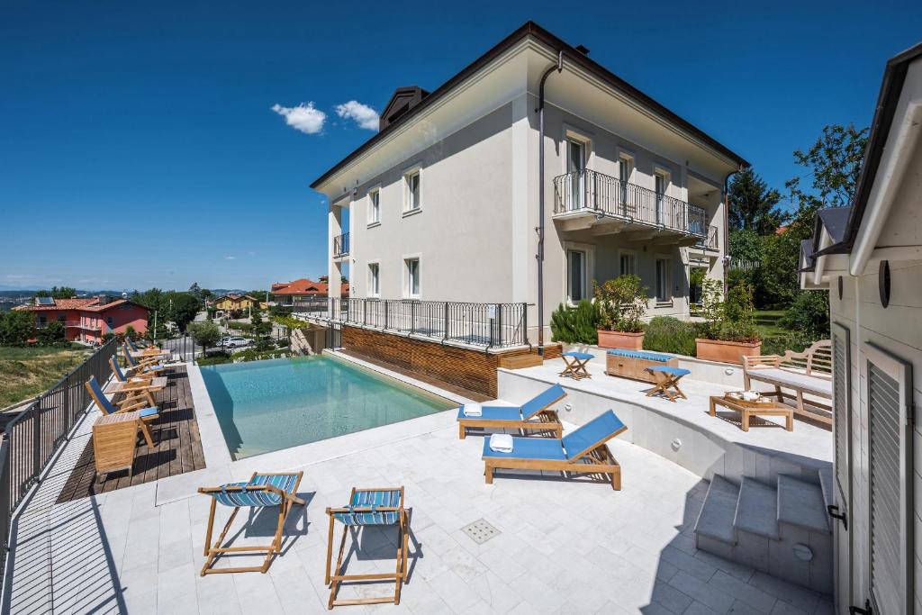 ein Haus mit einem Pool und einigen Stühlen in der Unterkunft Villa Vitae in Castiglione Falletto