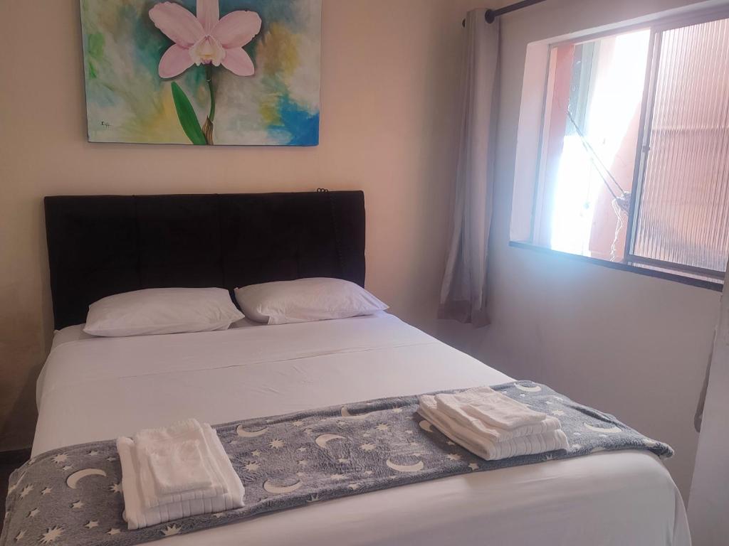 een slaapkamer met een bed met twee handdoeken erop bij Colonial House in Porto Seguro