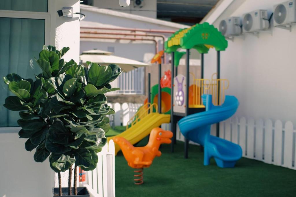 a play area with a playground with a slide at MARI Suites in Melaka