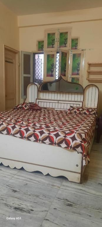 a large bed in a room with a bedspread on it at Devaa Homstay in Mau