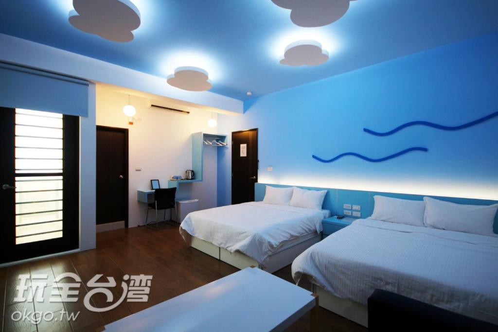 馬公市的住宿－澎湖晴風輕旅民宿，一间卧室设有两张床和蓝色的天花板