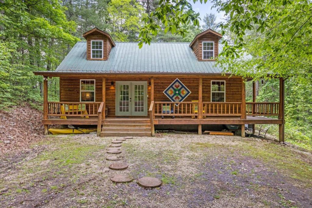 a cabin in the woods with a porch and a deck at WiFi & Pet Friendly - The Road's End in Rogers