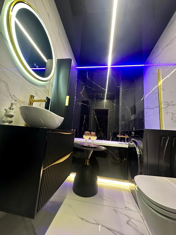 a bathroom with a sink and a mirror at Apart LUXE - Faktura VAT , Parking w garażu podziemnym , Taras in Koszalin