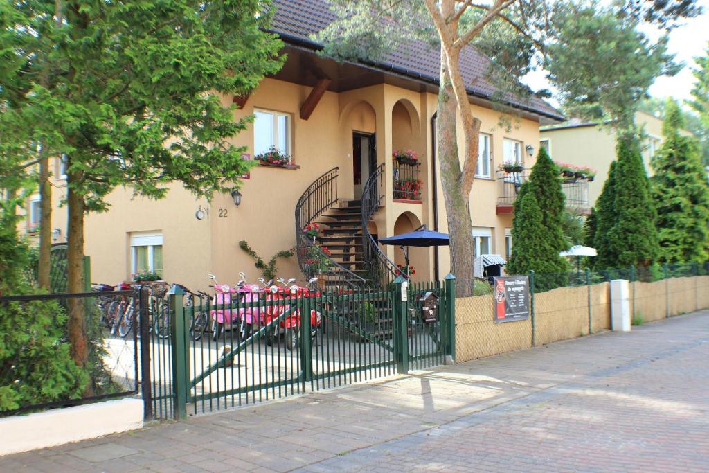 ポビエロボにあるBlekitna Laguna Pobierowoの階段のある家の前の緑の柵