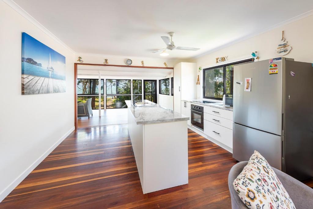 a kitchen with a refrigerator and a counter top at Pet friendly beachfront home- sleeps 8 in Toogoom