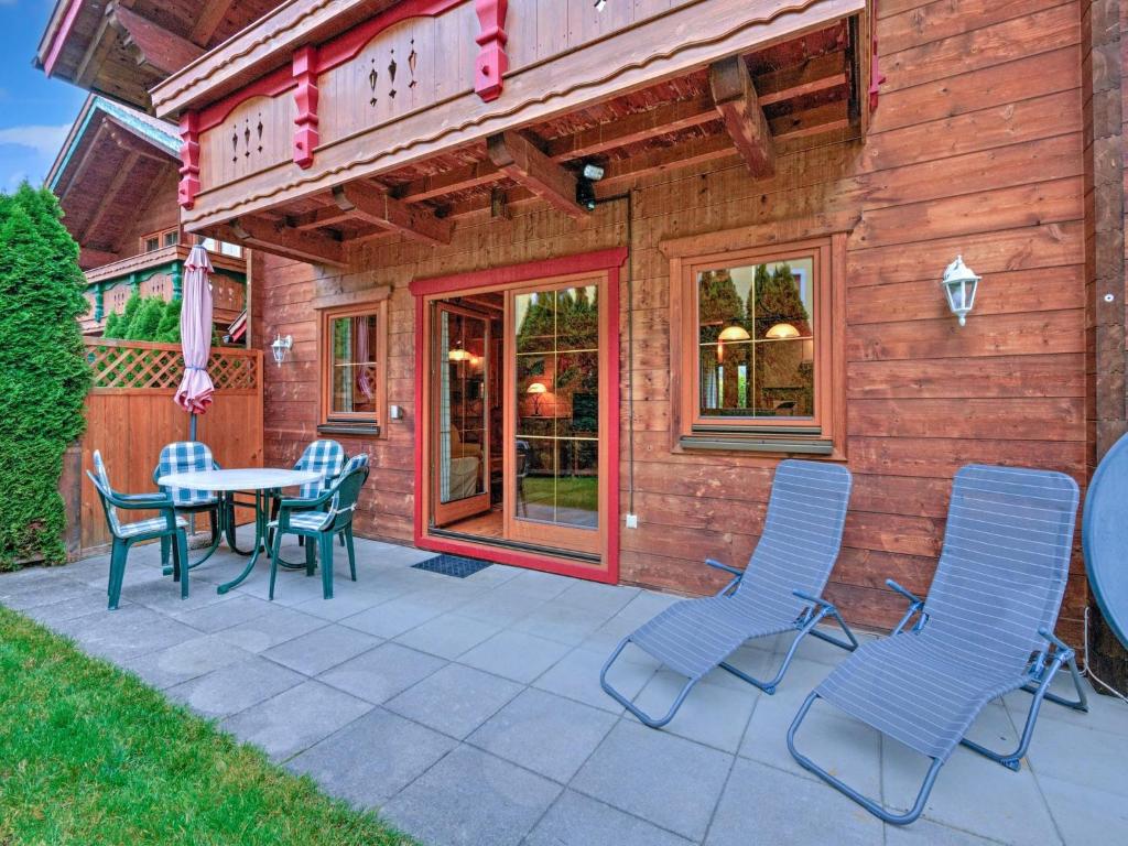 a patio with a table and chairs in front of a house at Scenic Stay in Feriendorf Wildschönau Chalet in Niederau