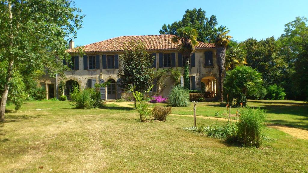 una casa grande con un patio delante en Maison Doat 1823, en Perchède