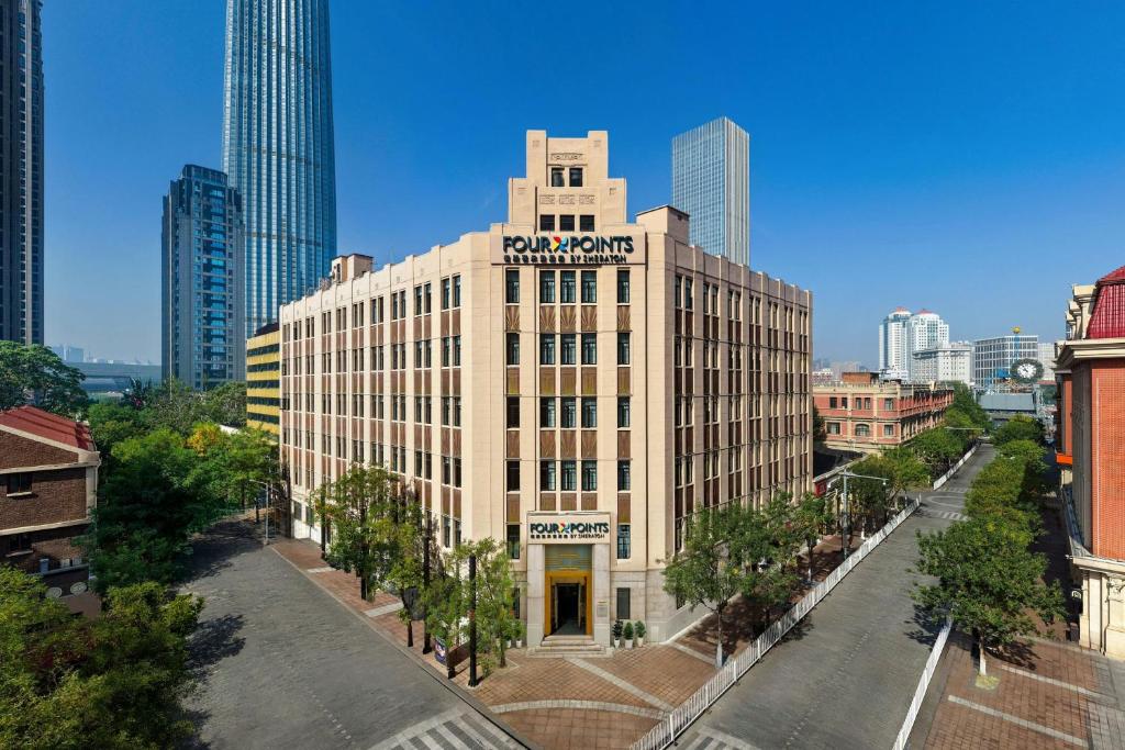 a large building with a sign on it in a city at Four Points by Sheraton Tianjin Jiefang Bridge in Tianjin