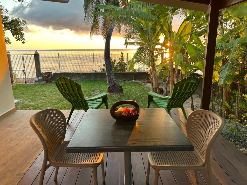 un tavolo di legno con sedie e una ciotola di frutta sopra di Bord de Mer, Coco Fare Beach, Tahiti a Punaauia
