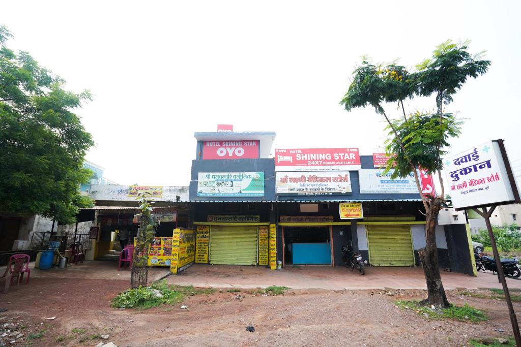 Un edificio con puertas amarillas y una palmera. en Hotel O Shining Star, en Bhilai