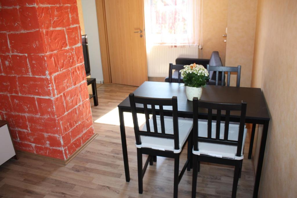 una sala da pranzo con tavolo, sedie e muro di mattoni di Privatzimmer San a Ringsheim