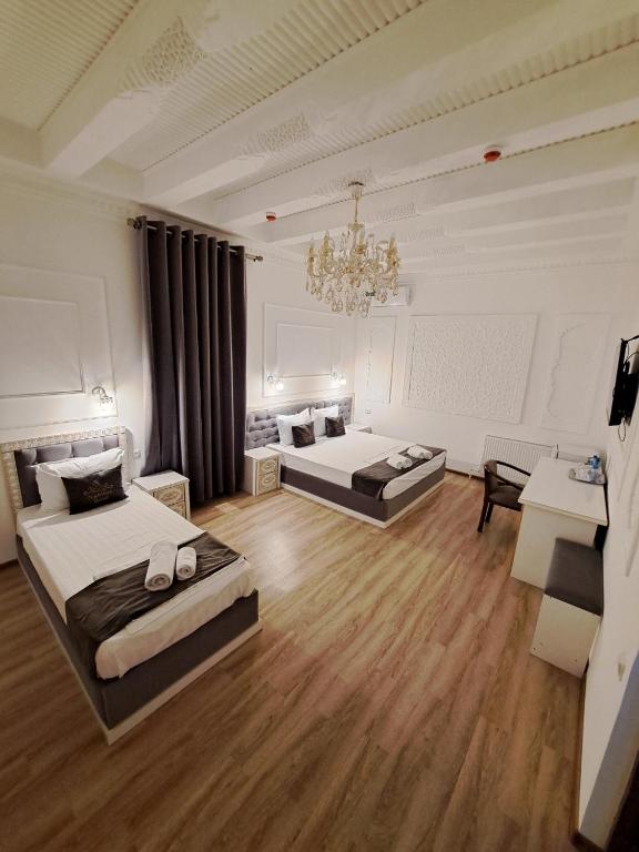 a large room with two beds and a chandelier at NABIBEK TERRACE Ponorama view old city in Bukhara