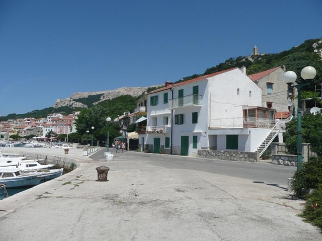 a group of buildings next to a harbor with boats at Apartment Mira in Baška